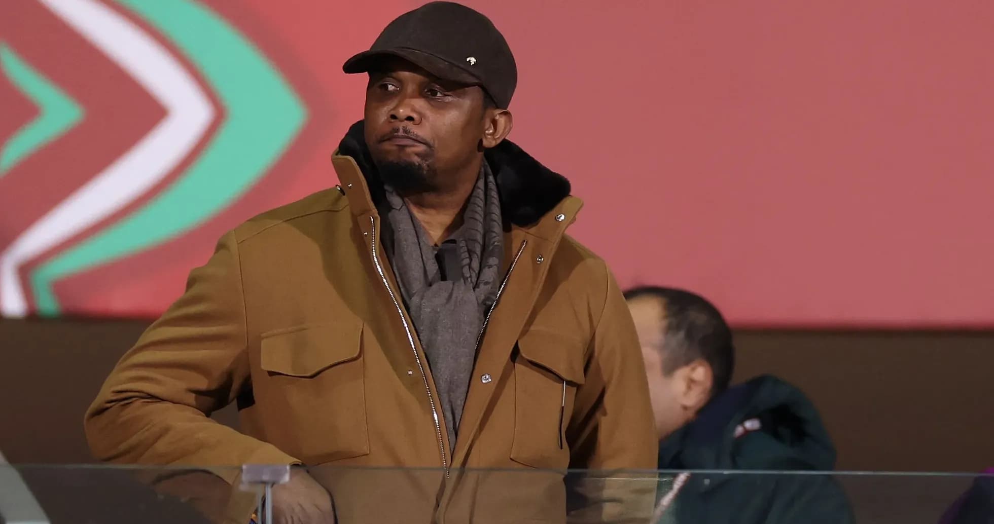 Homme en manteau observant un événement sportif