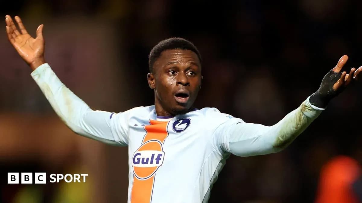 Joueur levant les bras sur le terrain de football