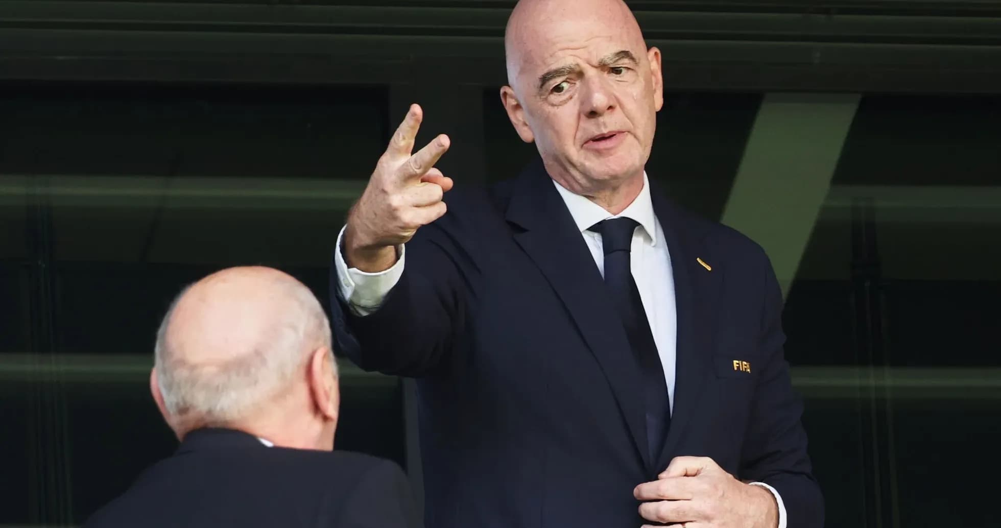 Homme en costume parlant avec un geste de la main