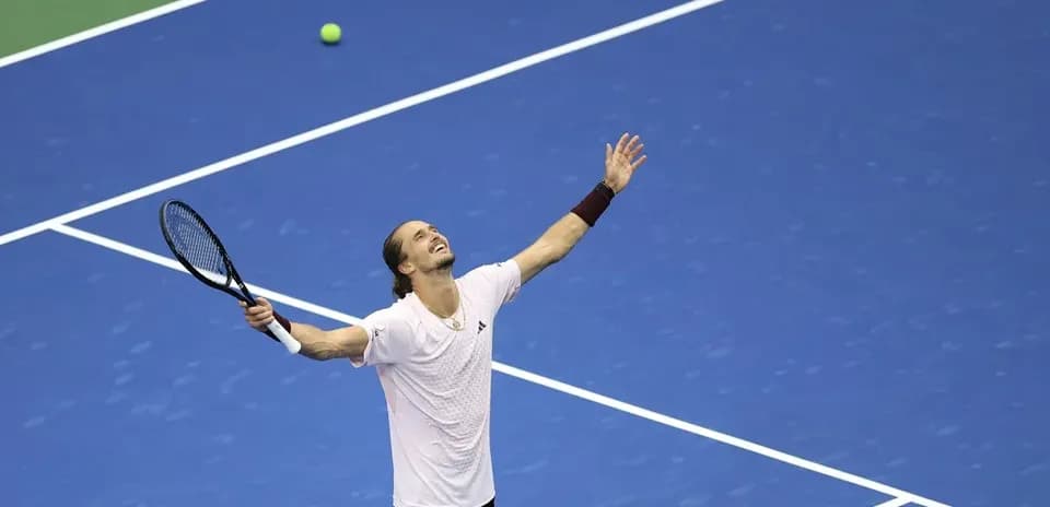 Joueur levant les bras sur un court de tennis