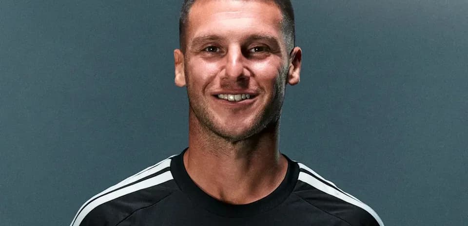 Joueur souriant en maillot noir avec logo