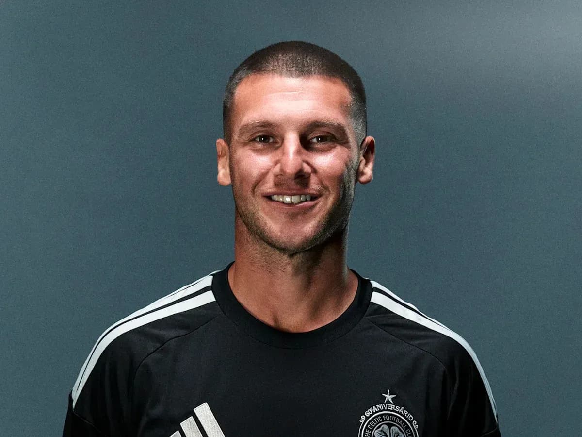 Joueur souriant en maillot noir avec logo