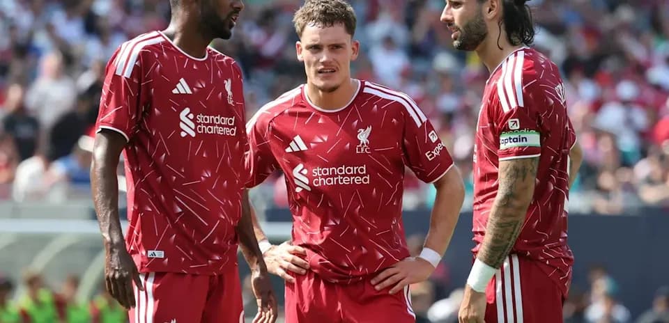 Trois joueurs de Liverpool en discussion sur le terrain