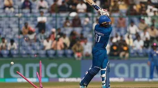 Batsman hitting the ball with stumps visible