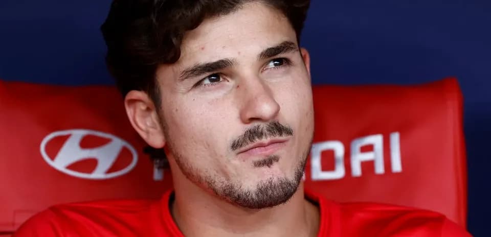Joueur assis sur le banc de touche en tenue rouge