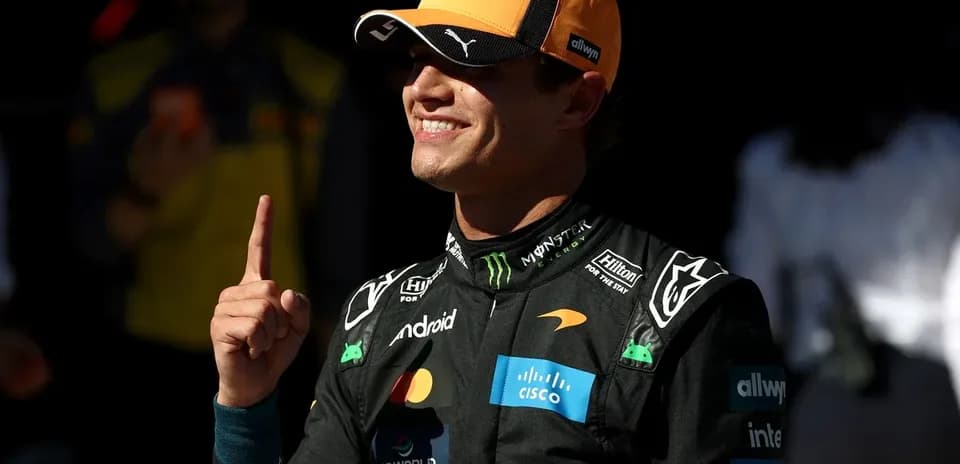 Pilote célébrant avec un doigt levé en combinaison de course