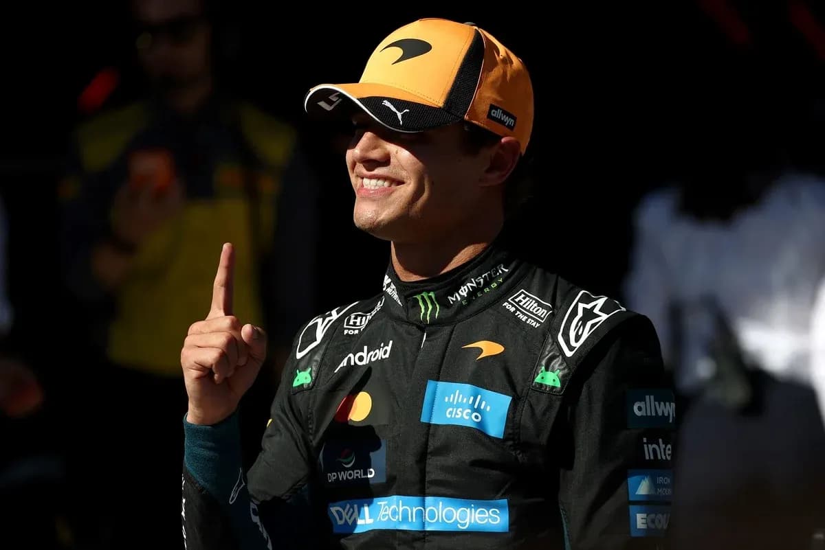 Pilote célébrant avec un doigt levé en combinaison de course