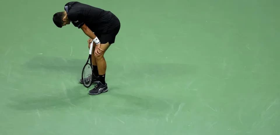 Joueur de tennis penché sur le court vert