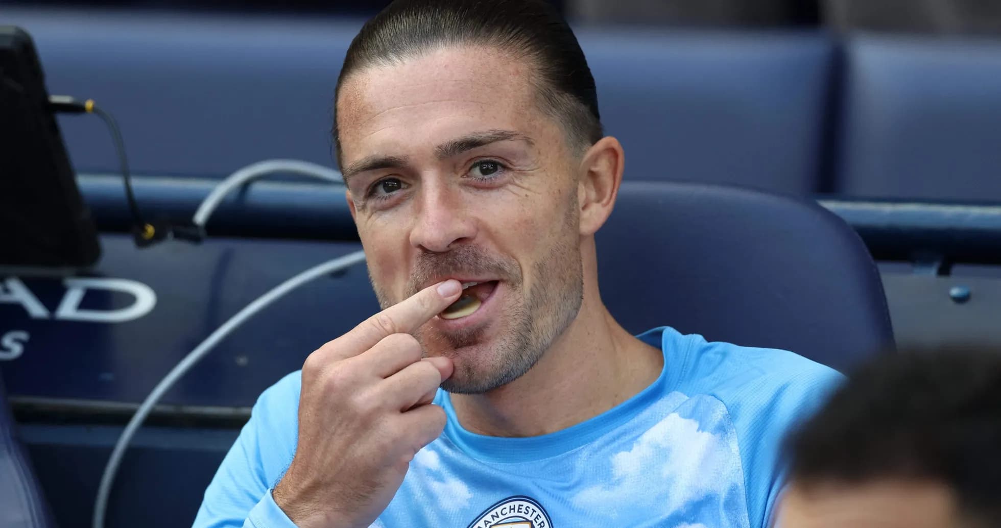 Joueur de Manchester City mangeant sur le banc