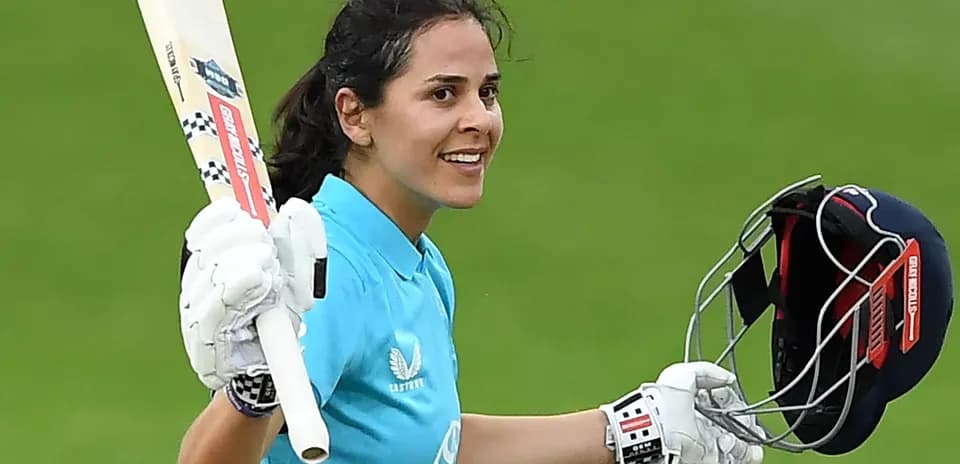 Joueuse de cricket célébrant une réussite avec une batte
