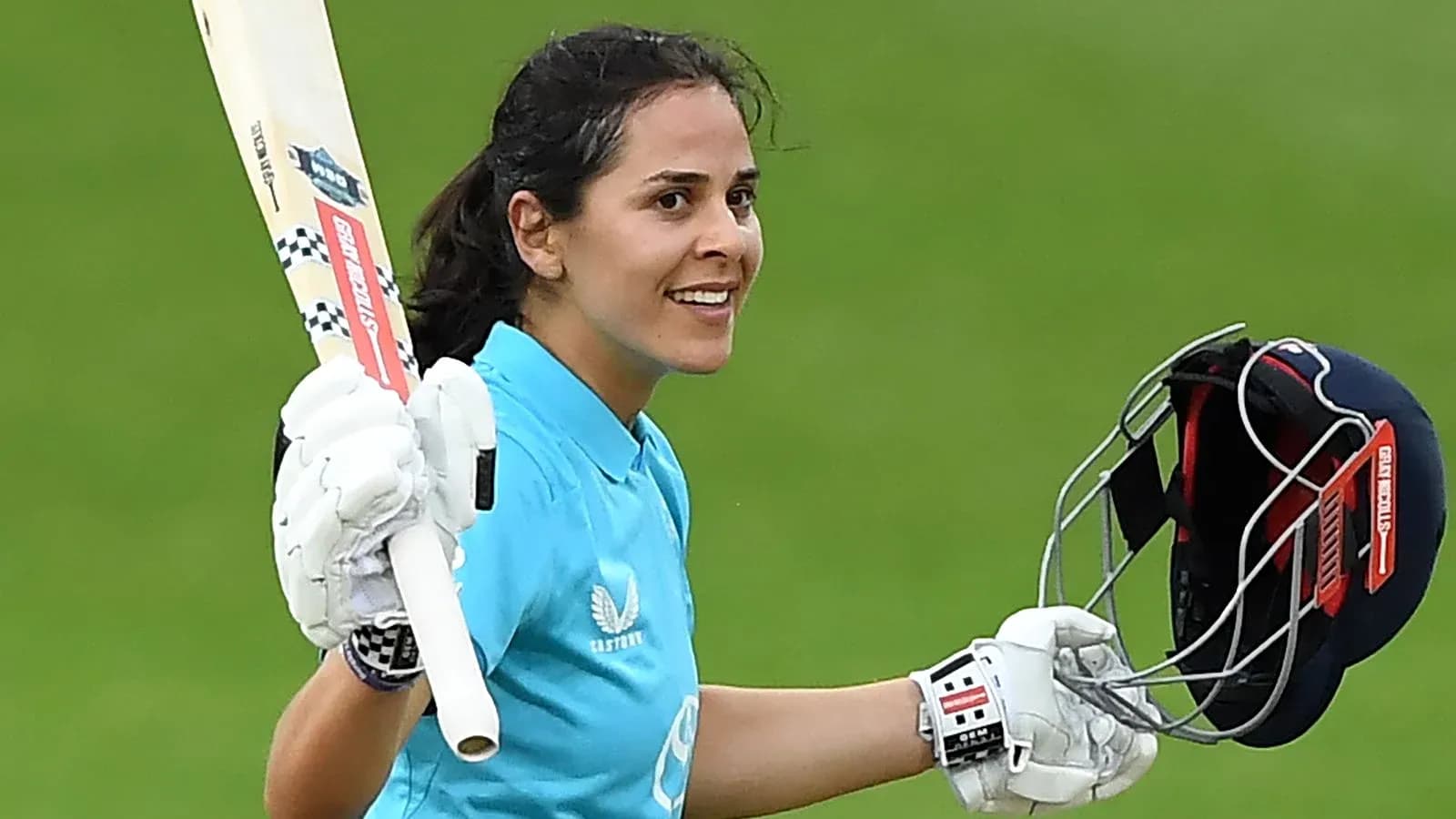 Joueuse de cricket célébrant une réussite avec une batte