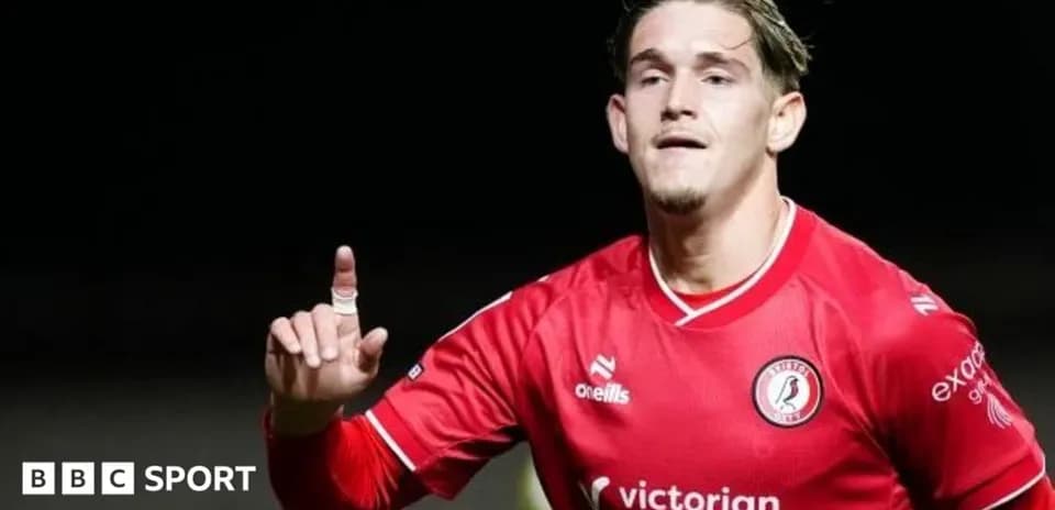 Joueur célébrant un but, vêtu d'un maillot rouge
