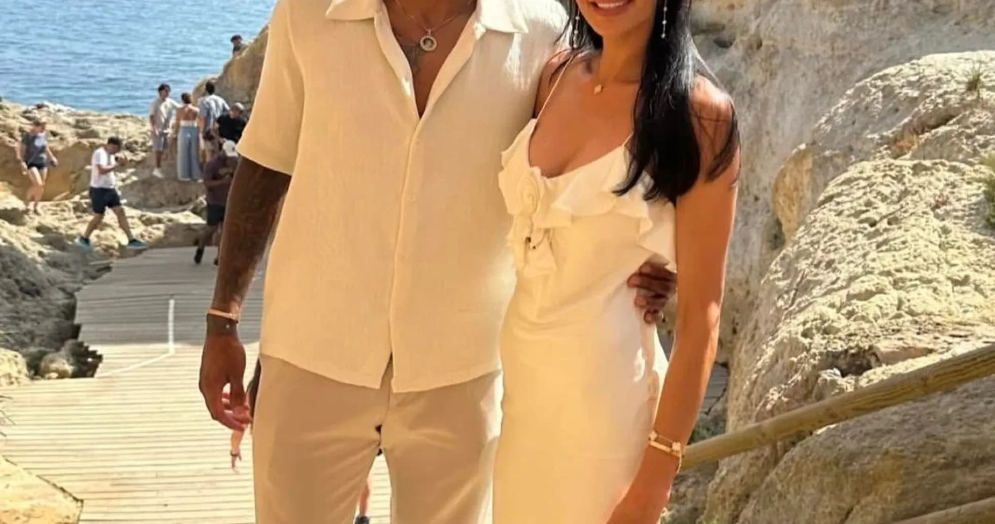 Couple posing on a rocky beach pathway