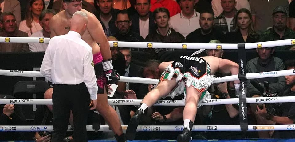 Boxer falling over the ropes during a match