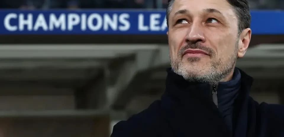 Entraîneur observant le match sous un panneau Champions League
