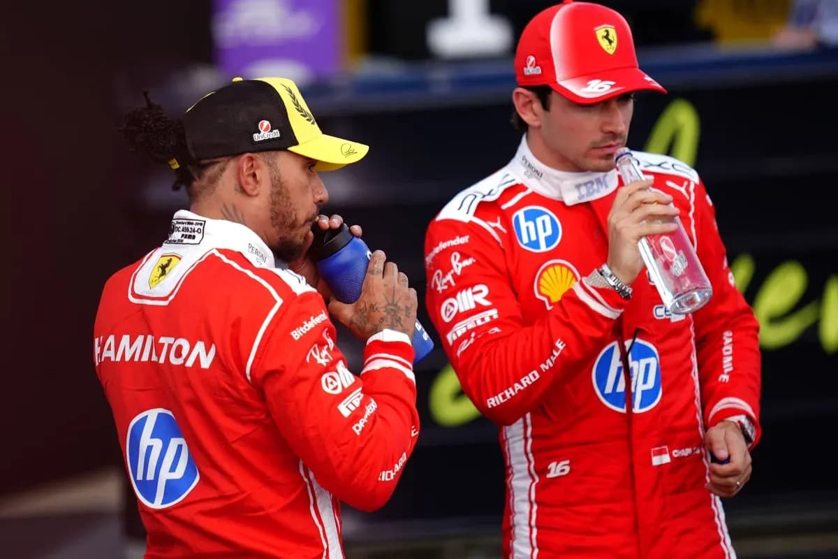 Deux pilotes en tenue de course buvant de l'eau