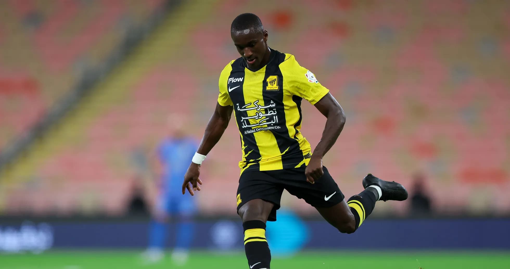 Joueur en uniforme jaune et noir tirant le ballon