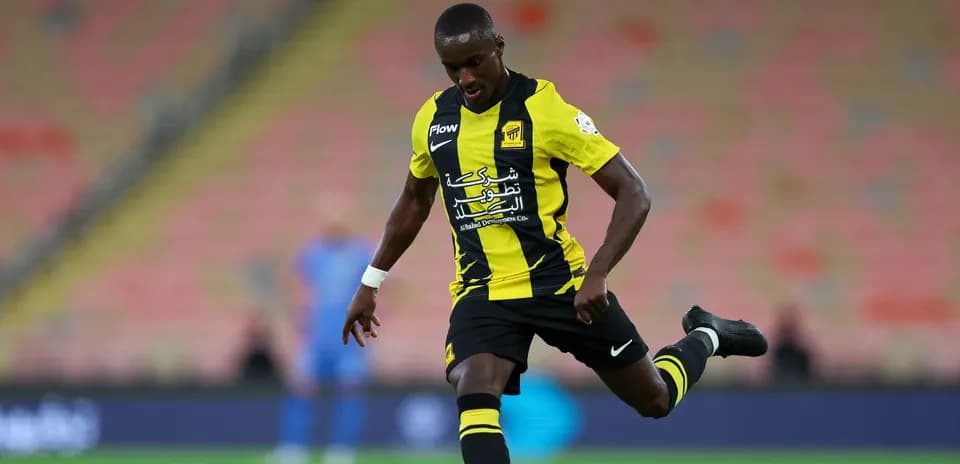 Joueur en uniforme jaune et noir tirant le ballon