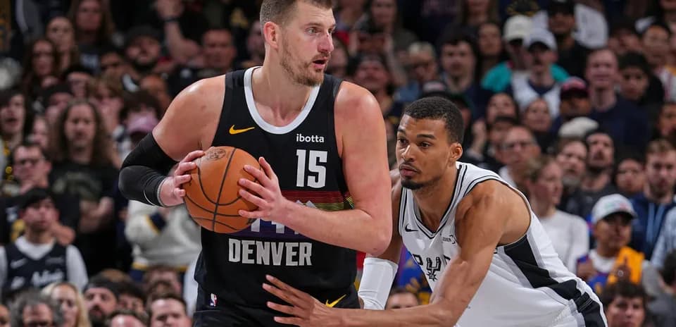 Joueur de Denver dribblant avec un défenseur proche