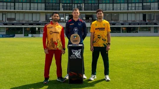 Trois joueurs posant avec un trophée sur le terrain
