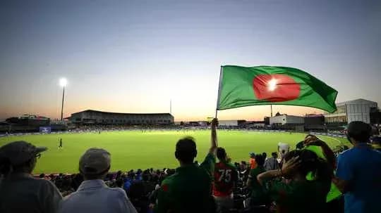 Spectators waving Bangladesh flag at cricket match