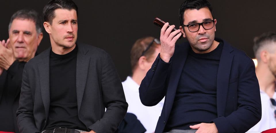 Deux hommes assis dans les tribunes du stade