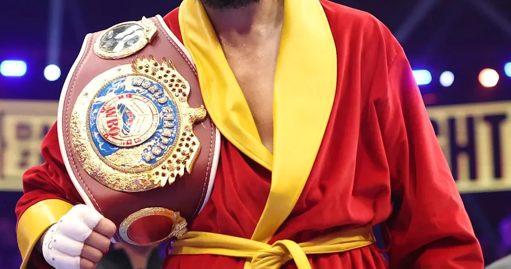 Boxeur en robe rouge tenant une ceinture de championnat