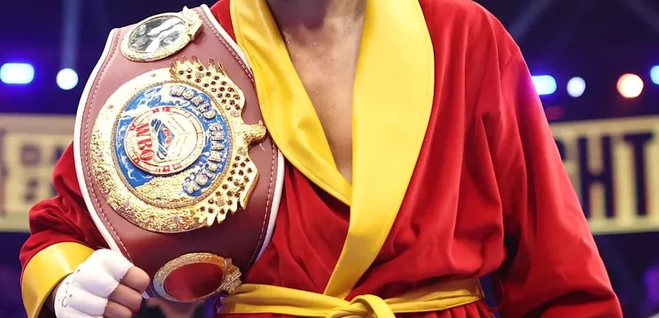 Boxeur en robe rouge tenant une ceinture de championnat