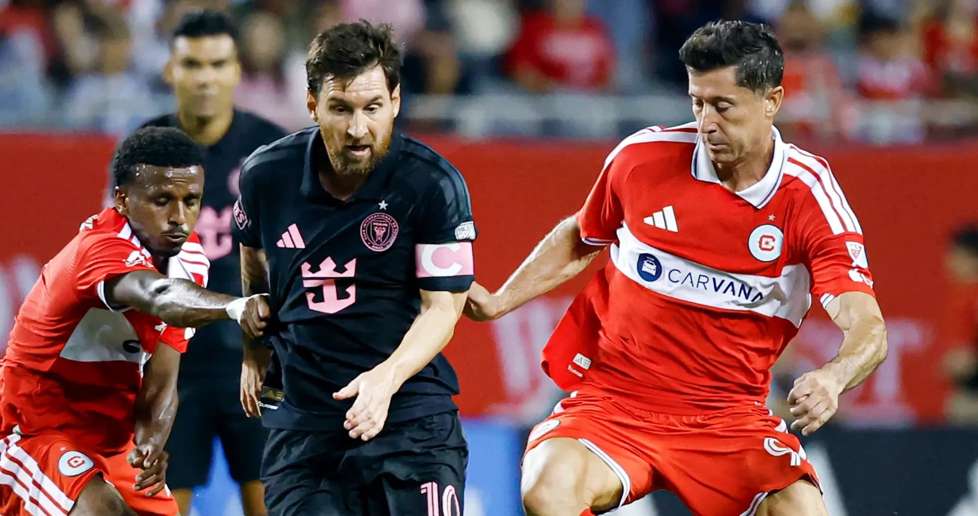 Messi dribbling past defenders during soccer match