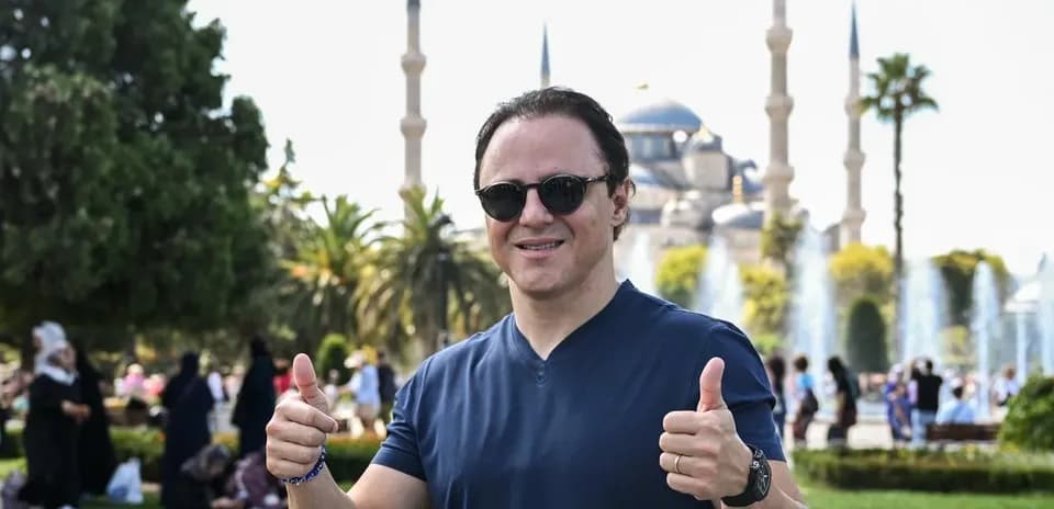 Homme souriant avec pouces levés devant la mosquée