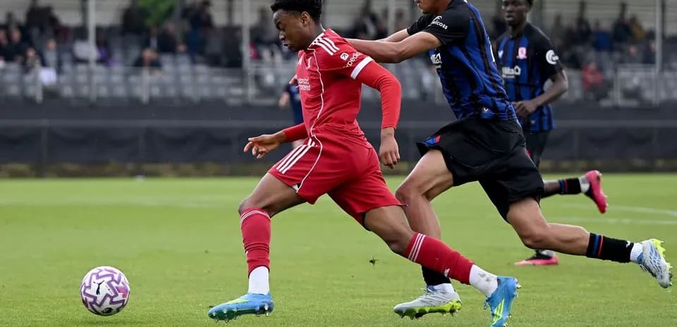 Joueur en rouge dribblant un adversaire en noir