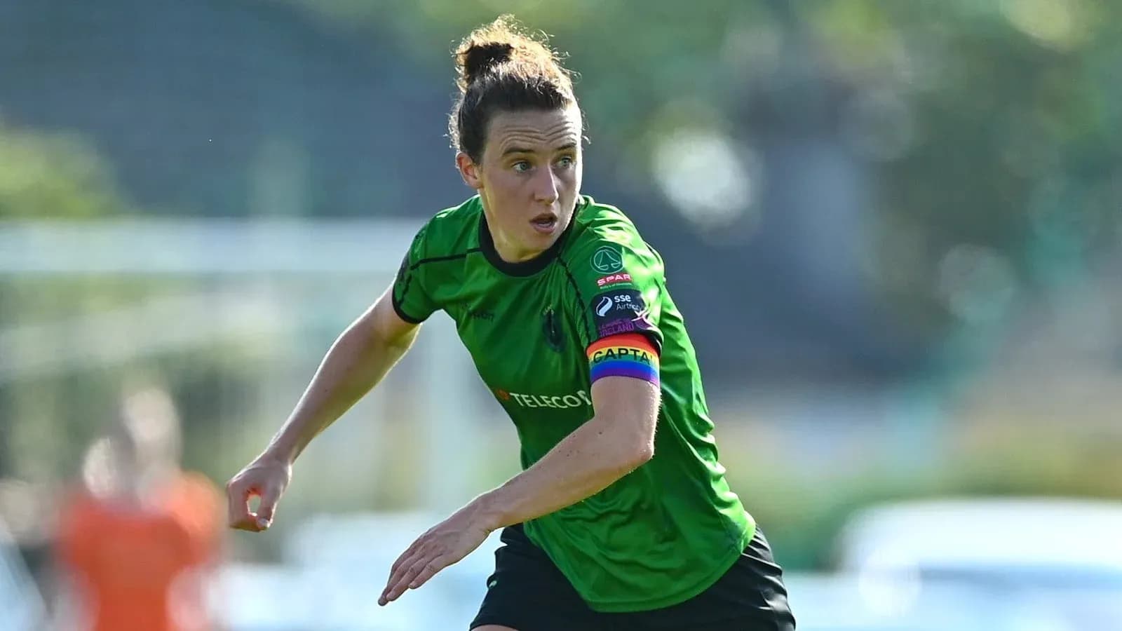 Joueuse en maillot vert courant sur le terrain