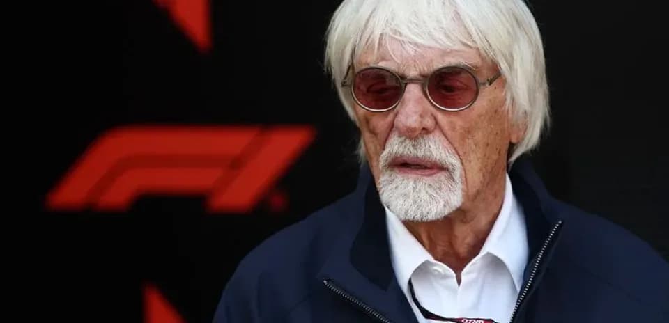 Person avec des lunettes devant un logo de F1
