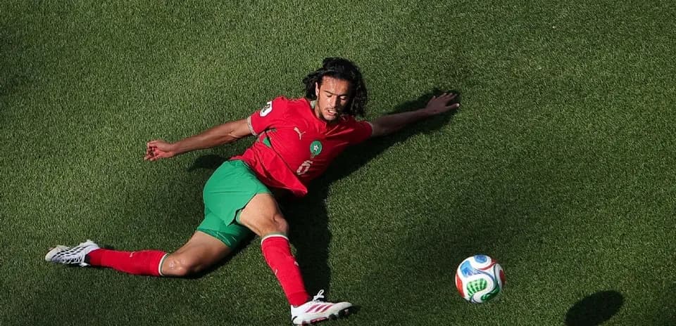 Joueur marocain tombé au sol avec un ballon