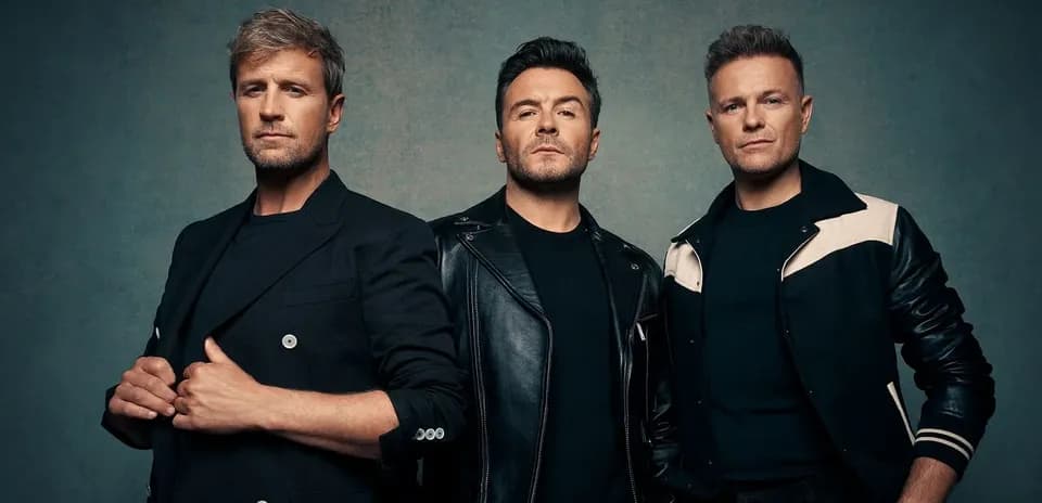 Trois hommes posant ensemble sur fond texturé