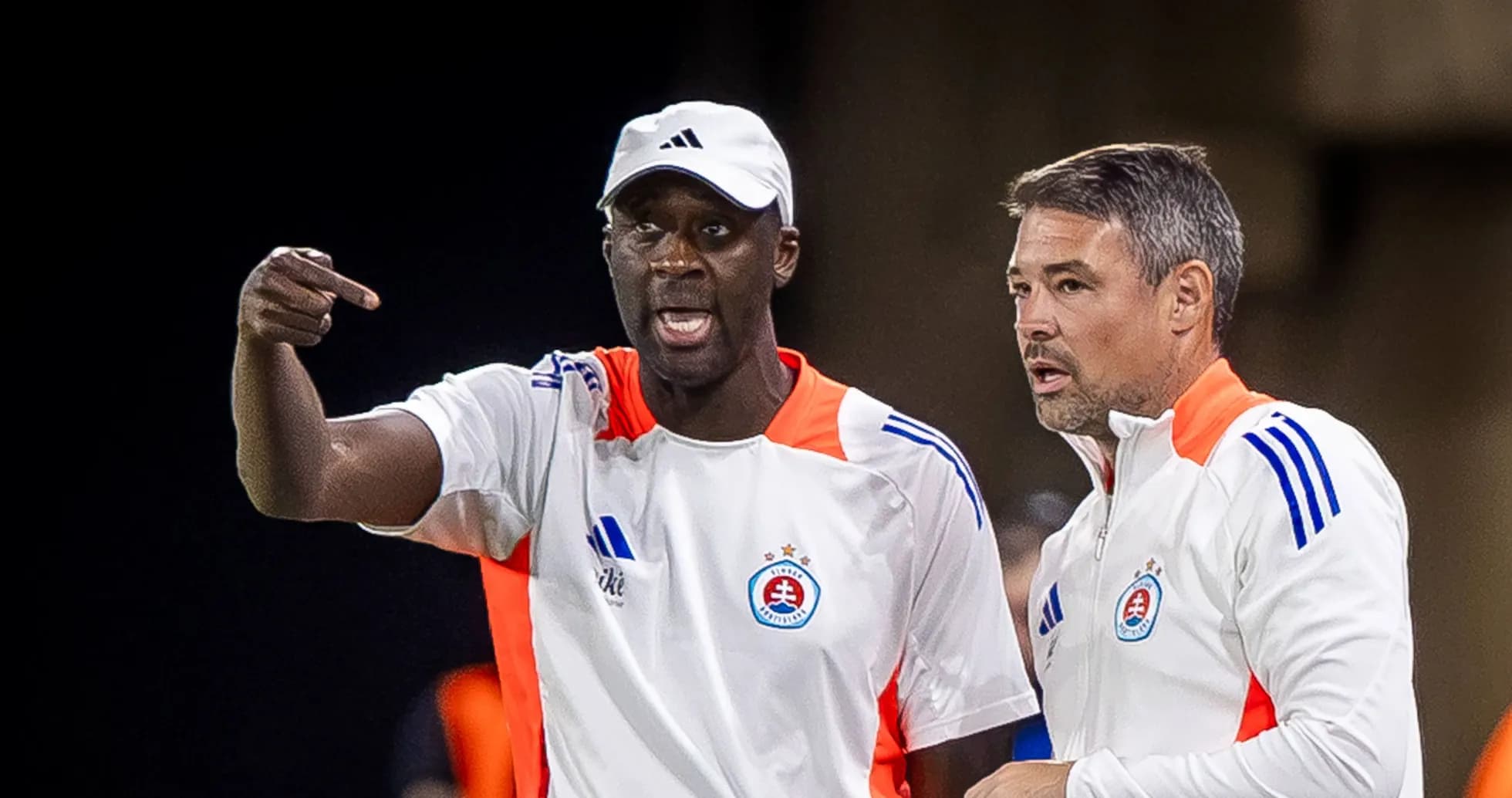 Deux entraîneurs discutant sur le bord du terrain