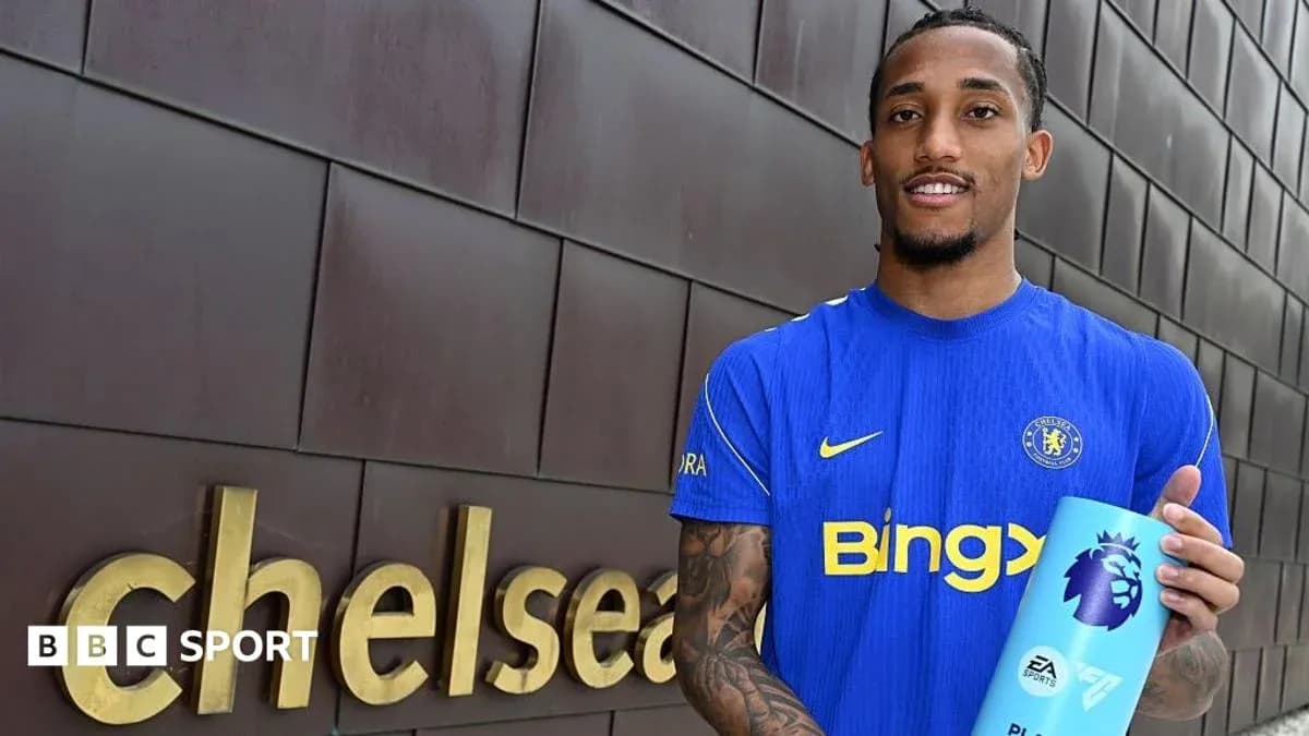 Joueur tenant un trophée près du logo Chelsea