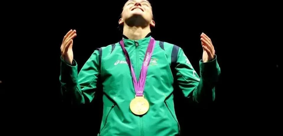 Athlete celebrating with gold medal at podium