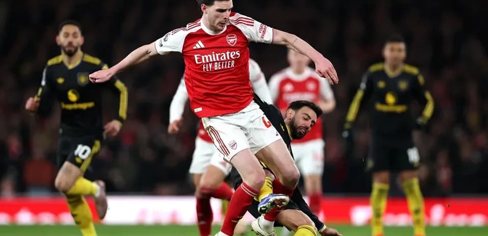 Un joueur d'Arsenal chutant après un tacle