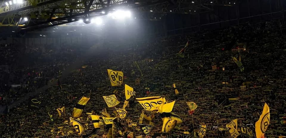 Supporters waving flags in a packed stadium