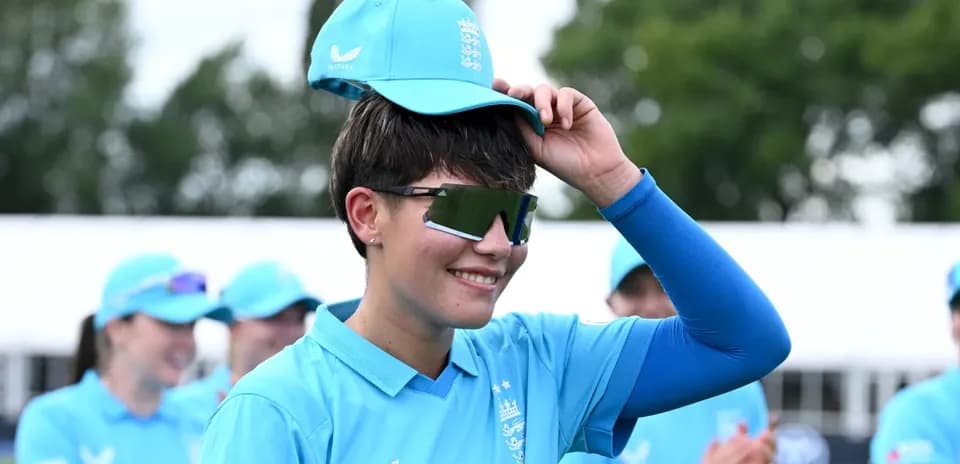 Joueuse de cricket en uniforme bleu avec casquette