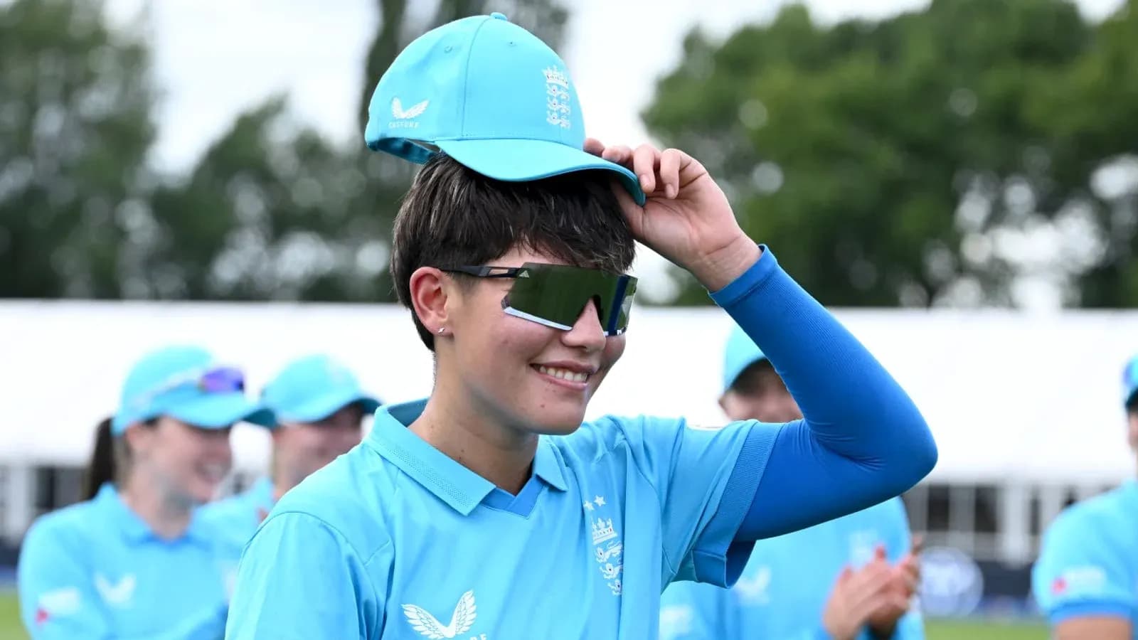 Joueuse de cricket en uniforme bleu avec casquette