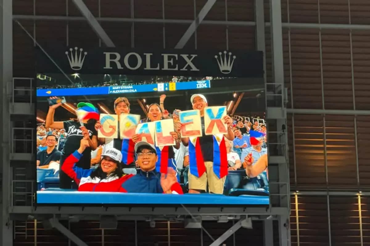 Supporters holding 'GO ALEX' signs in stadium