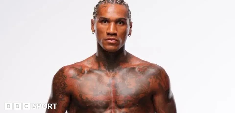 Athlete with tattoos posing against white background