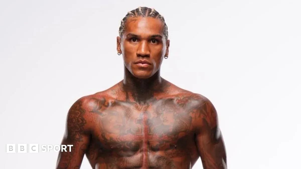 Athlete with tattoos posing against white background