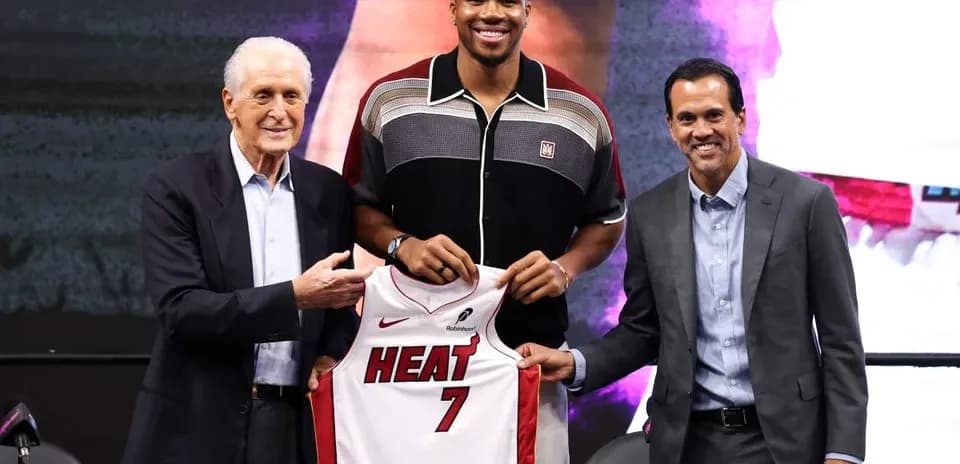 Joueur posant avec maillot des Miami Heat lors d'une conférence