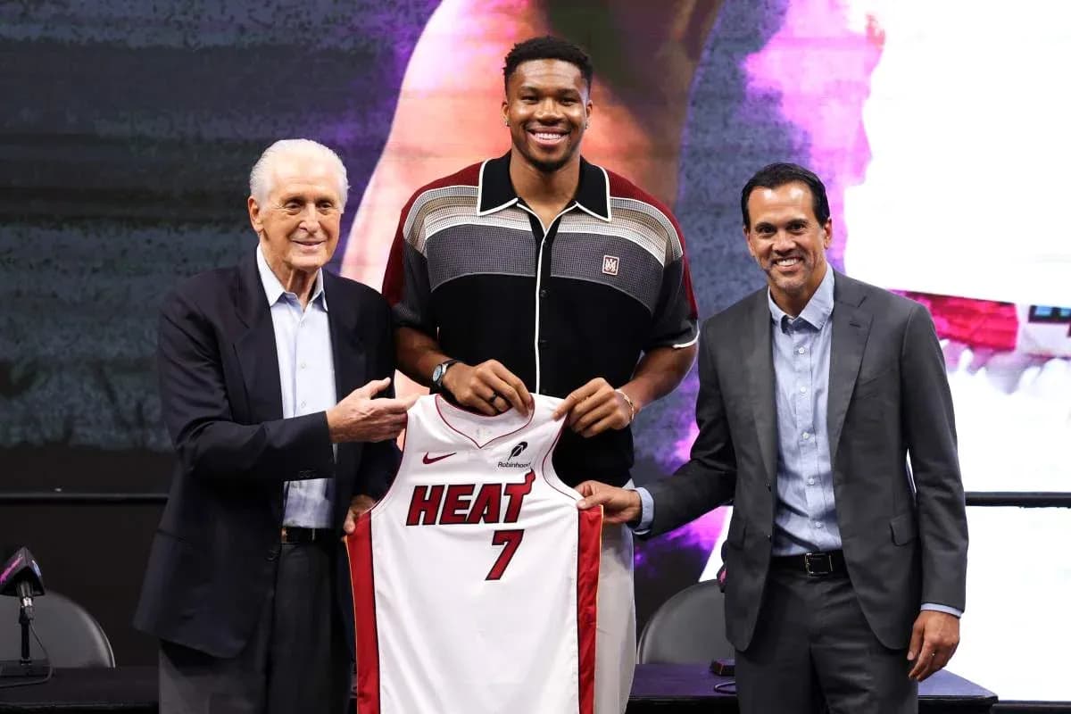 Joueur posant avec maillot des Miami Heat lors d'une conférence