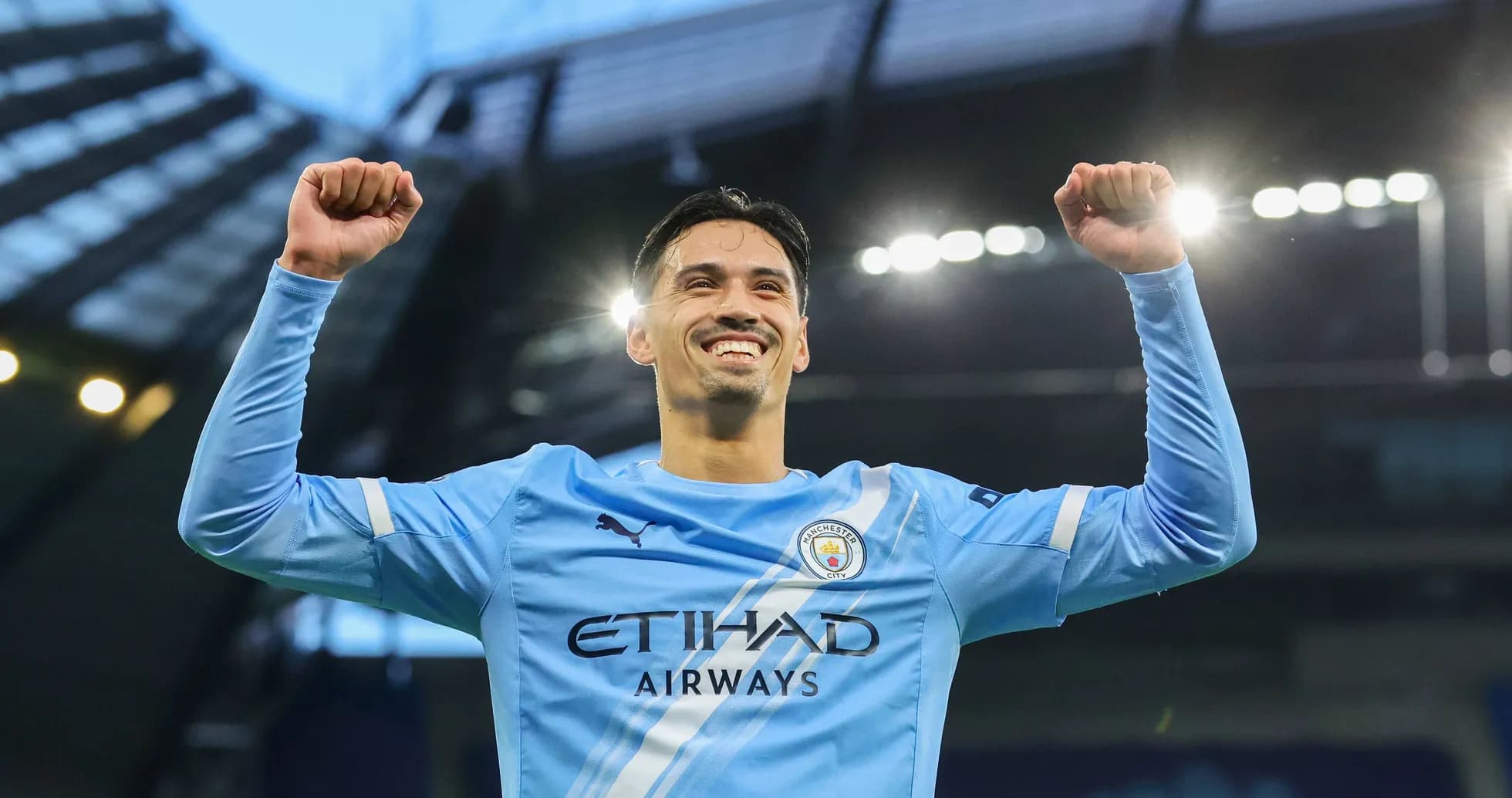 Joueur de Manchester City célébrant avec les bras levés