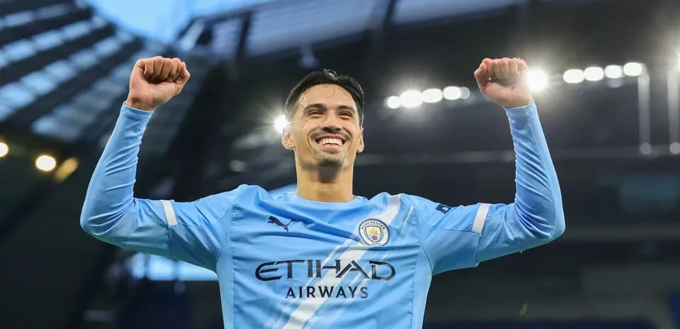 Joueur de Manchester City célébrant avec les bras levés
