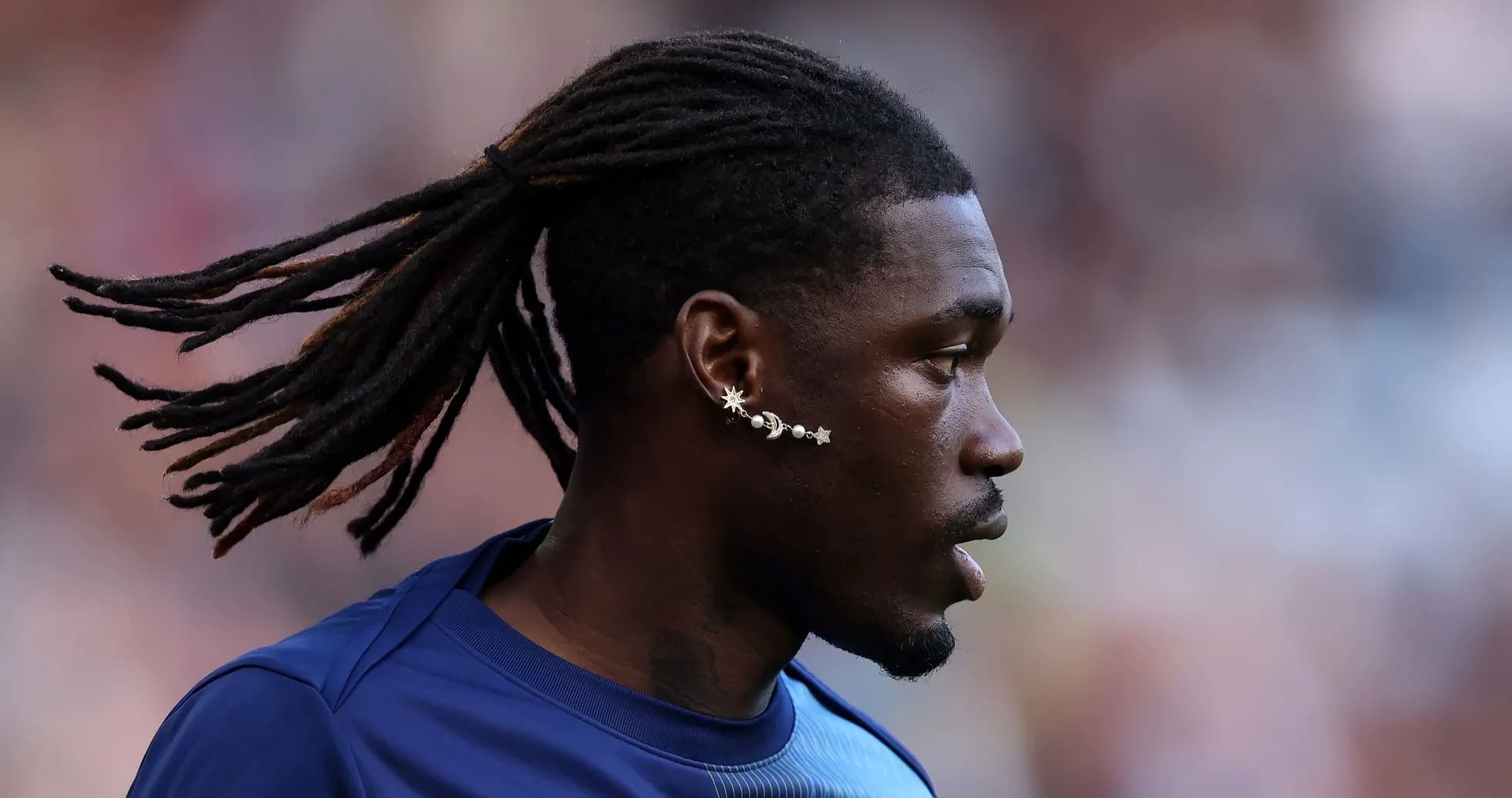 Joueur avec des dreadlocks et une boucle d'oreille